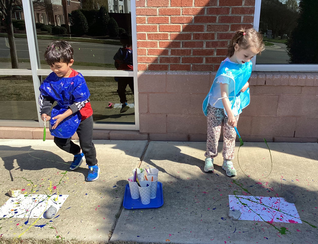 Children painting outdoors at Discovery Child Development Center